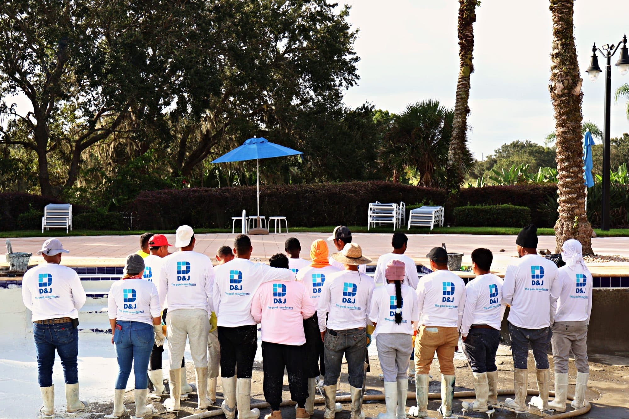 The D&J crew in company shirts beside a pool